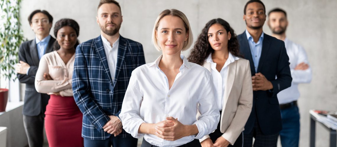 successful-businesswoman-standing-in-front-of-business-team-in-office.jpg